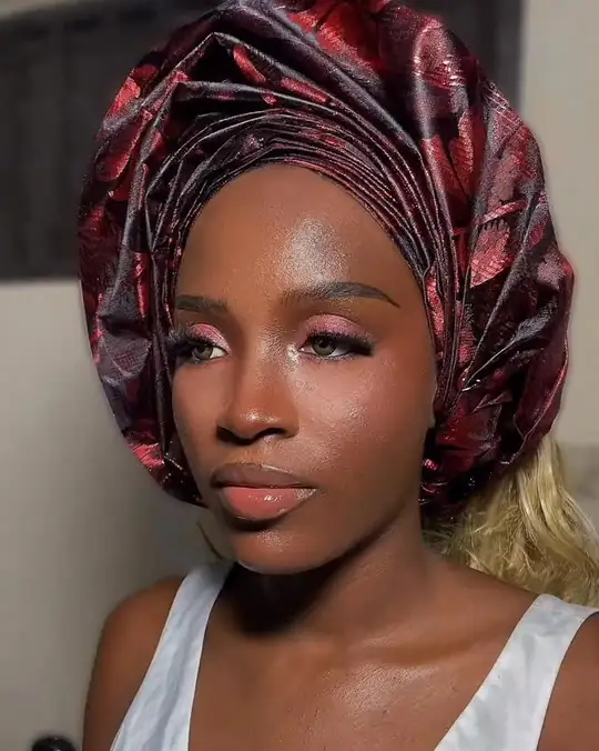 Bronze glam under a wine-red gele